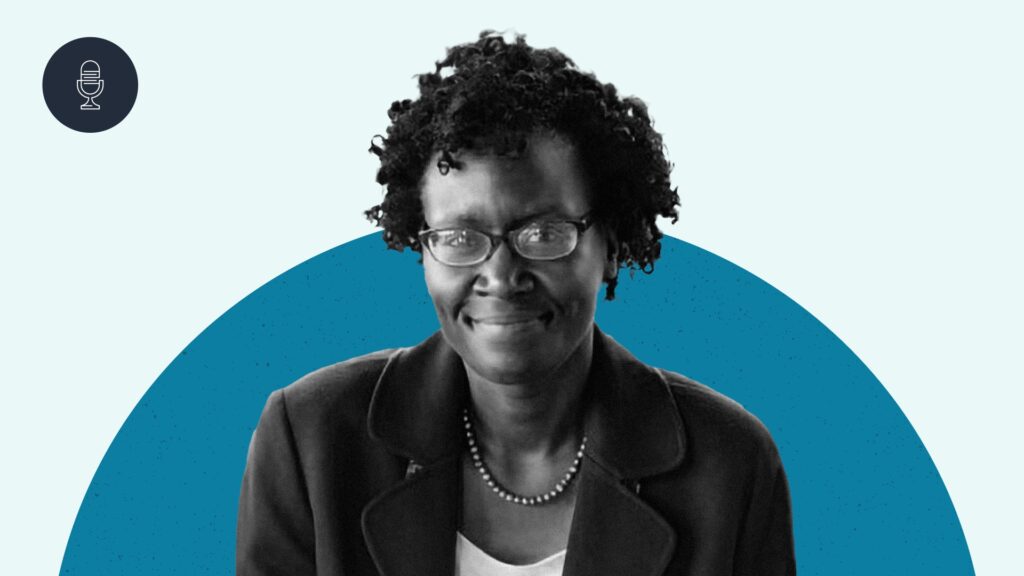 A black and white image of Dr. Yvette Alex-Assensoh smiling against dark blue and light blue semi-circles.