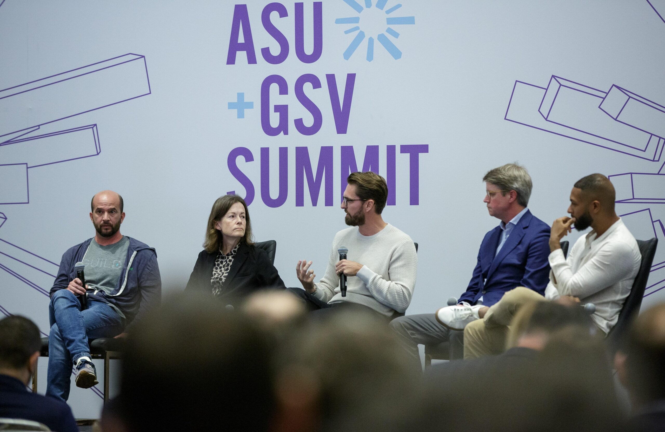 Lee Bradshaw holds a microphone as he speaks on a panel at the ASU+GSV Summit.
