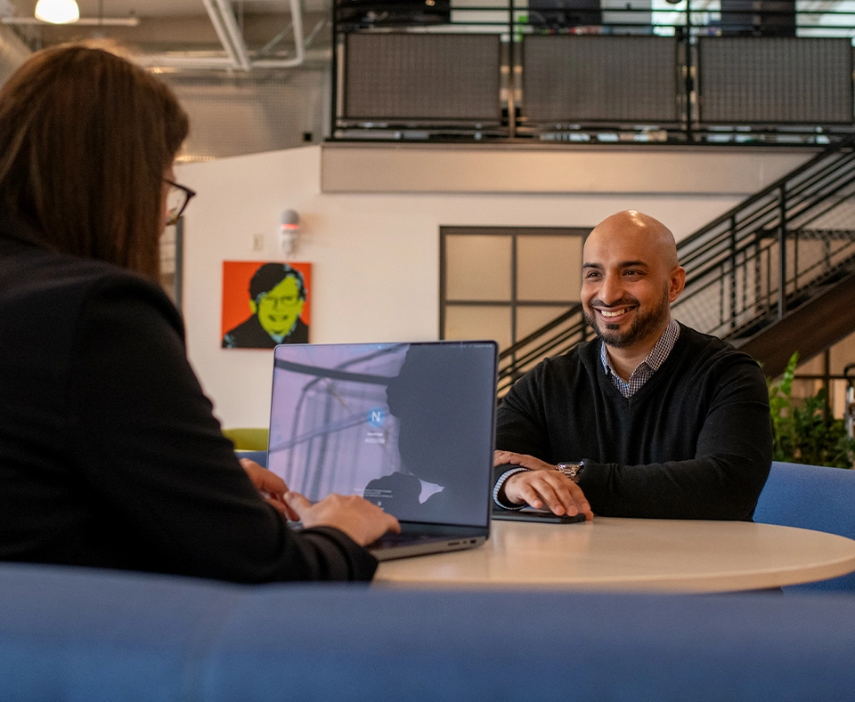 Two Noodle colleagues meet in an open office space.