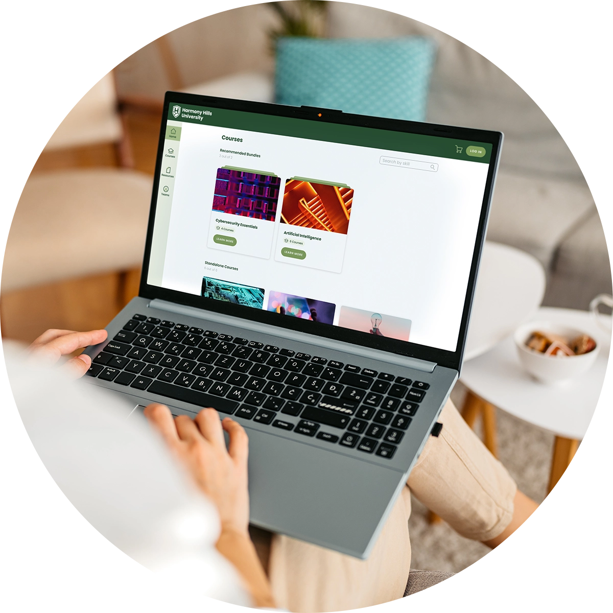 A closeup of hands typing on a laptop displaying a sample university's courses on the screen.