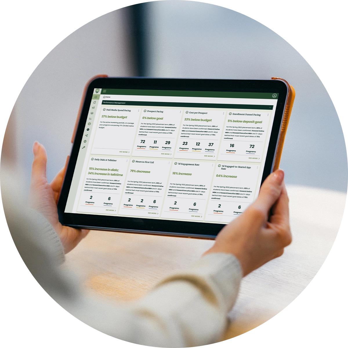 A closeup of hands holding a tablet that has statistics about a sample university on the screen.