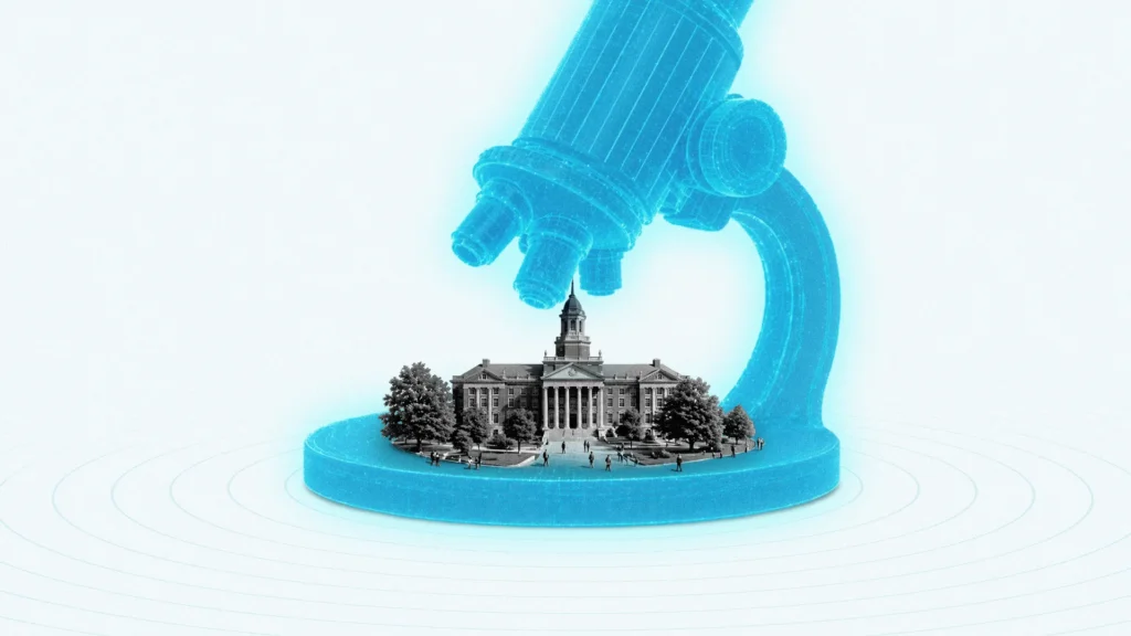 An oversized microscope looks down on an institutional building on a university campus.