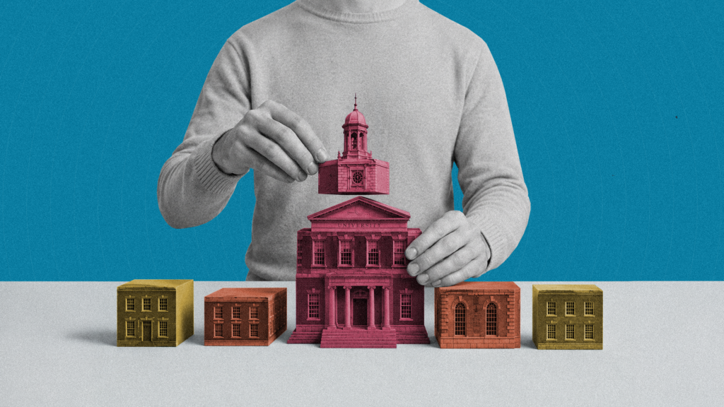A closeup of a person's hands assembling a collection of institutional buildings on a table.